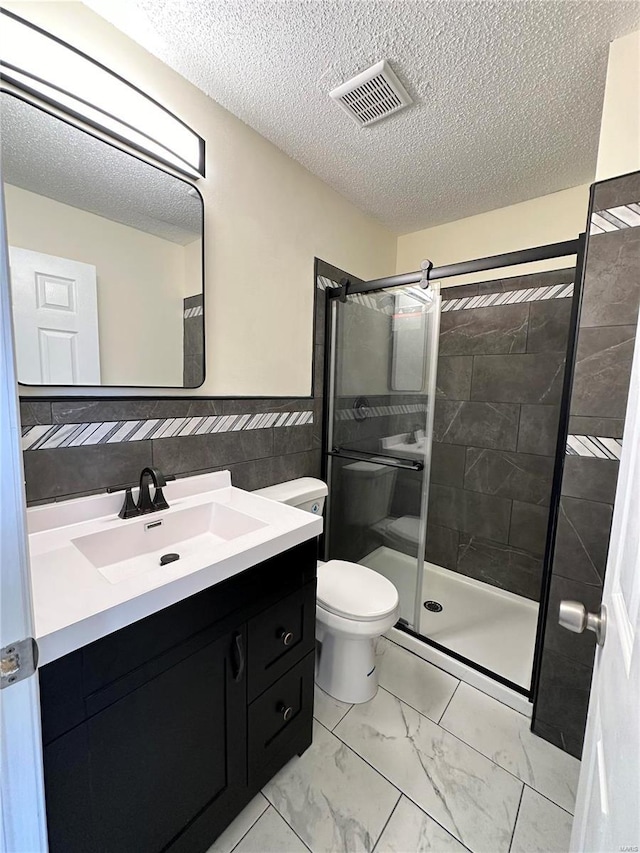 bathroom featuring vanity, toilet, tile walls, a textured ceiling, and walk in shower