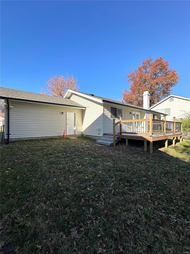 rear view of property featuring a yard and a deck