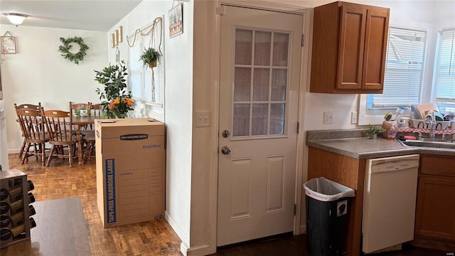 kitchen featuring a textured ceiling, white dishwasher, dark wood-type flooring, and sink