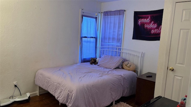 bedroom with dark hardwood / wood-style floors