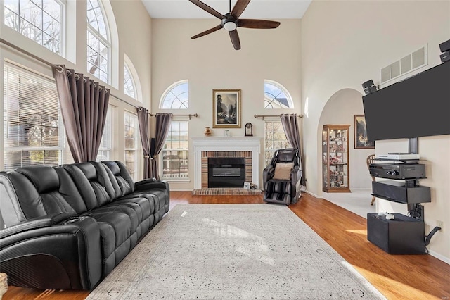 living room featuring hardwood / wood-style floors, a towering ceiling, and a healthy amount of sunlight