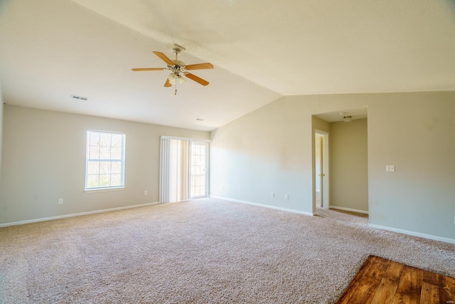 unfurnished room featuring ceiling fan, carpet floors, and vaulted ceiling