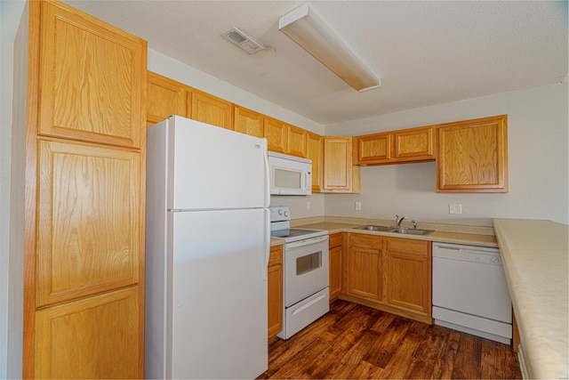 kitchen featuring a textured ceiling, sink, dark wood-type flooring, and white appliances