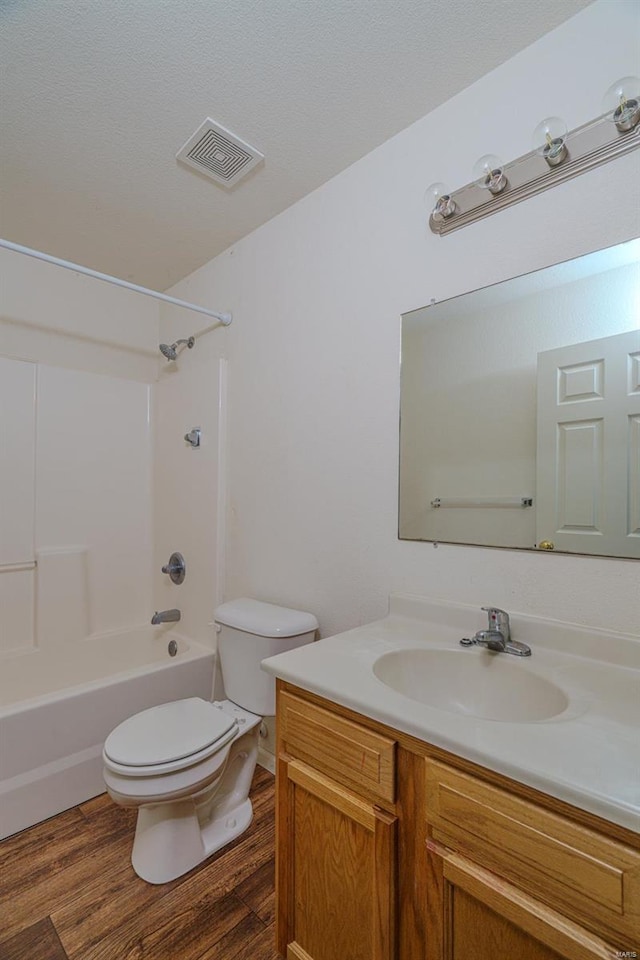 full bathroom with shower / bath combination, vanity, wood-type flooring, and toilet