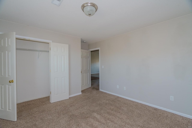 unfurnished bedroom featuring light carpet and a closet