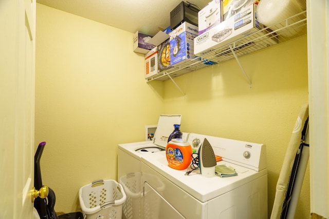 clothes washing area with washing machine and dryer