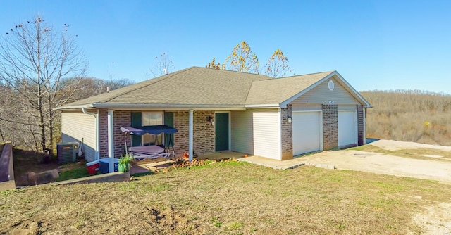 single story home featuring a garage, a front yard, and central AC