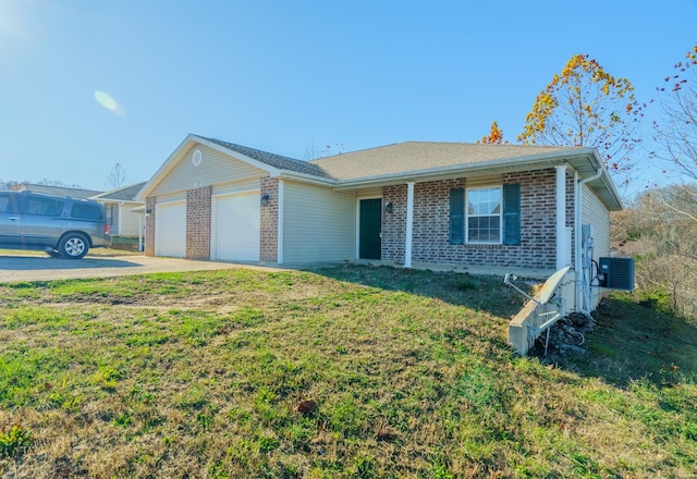 ranch-style home with central air condition unit, a front lawn, and a garage