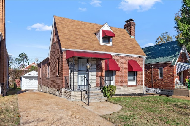 view of front facade featuring an outbuilding, a garage, and a front lawn