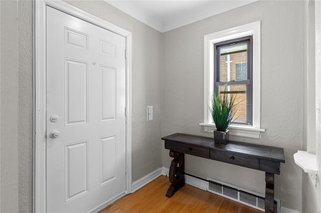 doorway to outside with crown molding and hardwood / wood-style floors