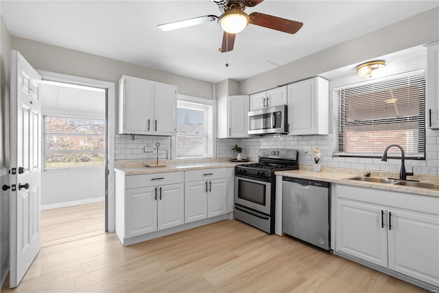 kitchen featuring a healthy amount of sunlight, white cabinetry, and stainless steel appliances