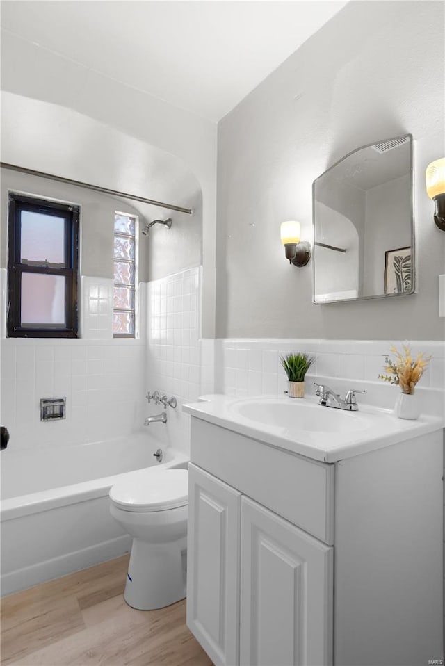 full bathroom featuring tiled shower / bath, toilet, vanity, and hardwood / wood-style flooring