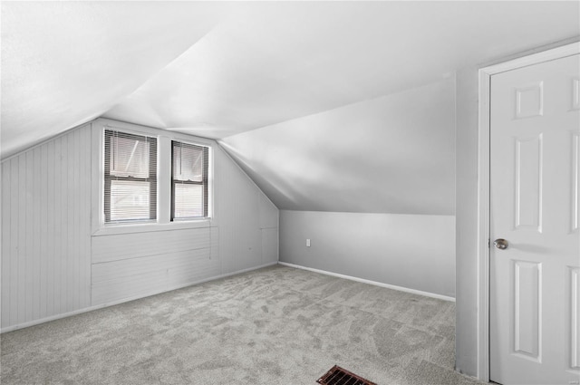 bonus room with light colored carpet and lofted ceiling