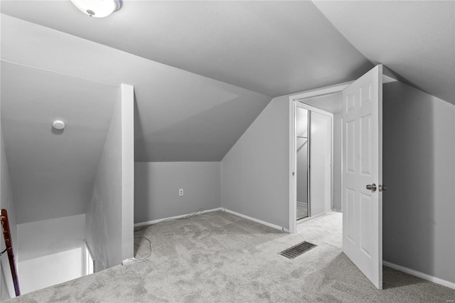 bonus room with light colored carpet and lofted ceiling