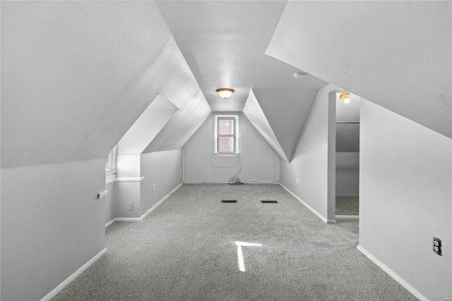 bonus room featuring light carpet and vaulted ceiling