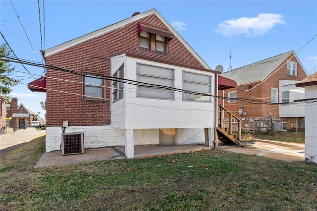 back of house featuring a yard and central AC unit