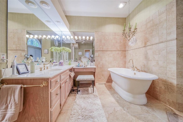 bathroom with tile walls, vanity, tile patterned floors, and a bathing tub