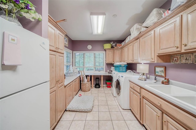 laundry room with cabinets, light tile patterned flooring, separate washer and dryer, and sink