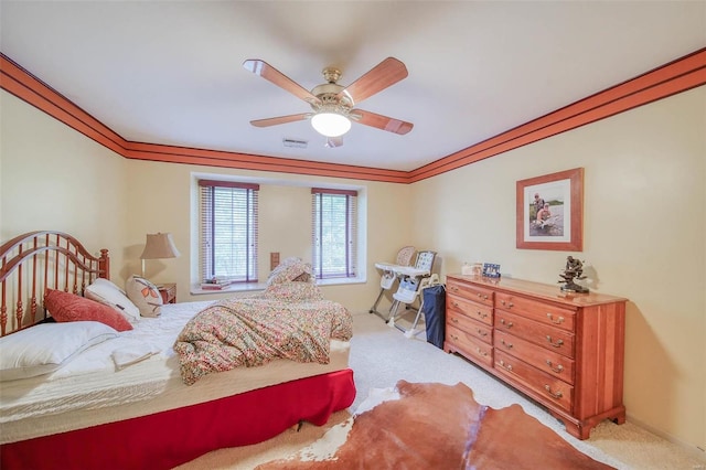 bedroom featuring light carpet, crown molding, and ceiling fan