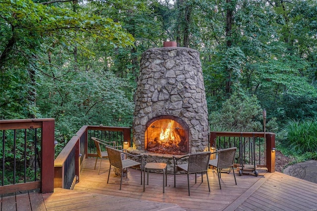 wooden terrace featuring an outdoor stone fireplace