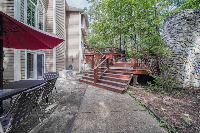 view of patio / terrace featuring a deck, outdoor dining area, and stairway