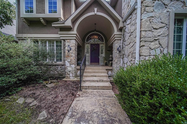 view of exterior entry with stone siding and stucco siding