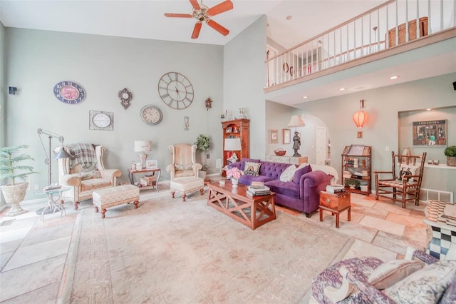 living area with ceiling fan, a high ceiling, visible vents, and recessed lighting