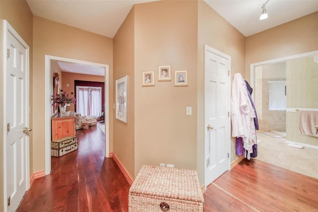 hallway with baseboards and wood finished floors