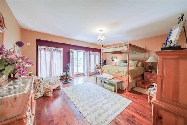 bedroom featuring light wood-type flooring and an inviting chandelier