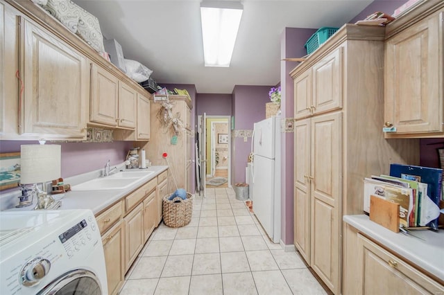 kitchen with light countertops, light brown cabinetry, freestanding refrigerator, light tile patterned flooring, and a sink