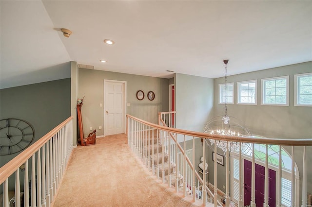 hall featuring a chandelier, recessed lighting, light carpet, visible vents, and an upstairs landing