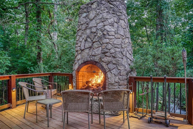 wooden deck with an outdoor stone fireplace