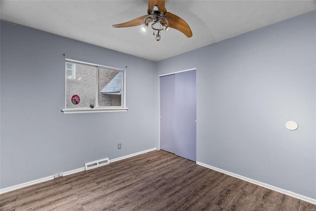 unfurnished bedroom with ceiling fan, a closet, and hardwood / wood-style flooring