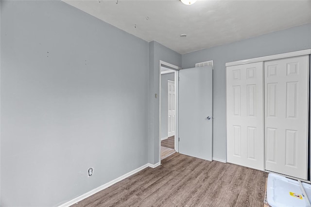 unfurnished bedroom with a closet and light hardwood / wood-style flooring