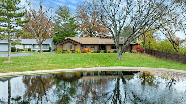 rear view of property featuring a lawn and a water view