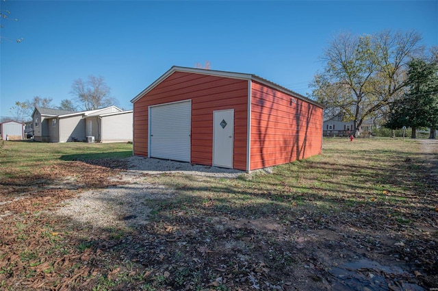 view of outdoor structure featuring a lawn and a garage