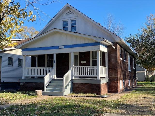 bungalow-style house with covered porch and a front lawn