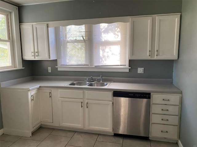 kitchen with white cabinetry, sink, light tile patterned flooring, and stainless steel dishwasher