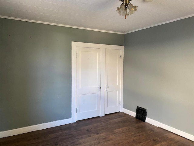 unfurnished bedroom featuring crown molding and dark hardwood / wood-style floors