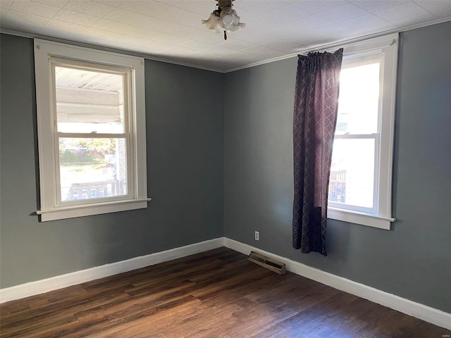 empty room with crown molding and dark hardwood / wood-style floors