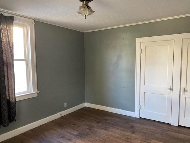 empty room with crown molding and dark hardwood / wood-style floors