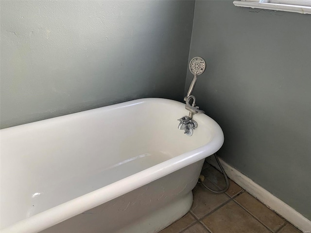 bathroom with tile patterned floors and a bath