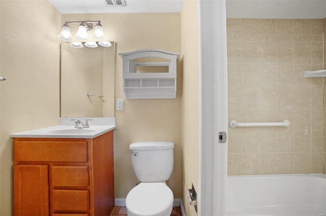 bathroom with vanity, toilet, and a textured ceiling