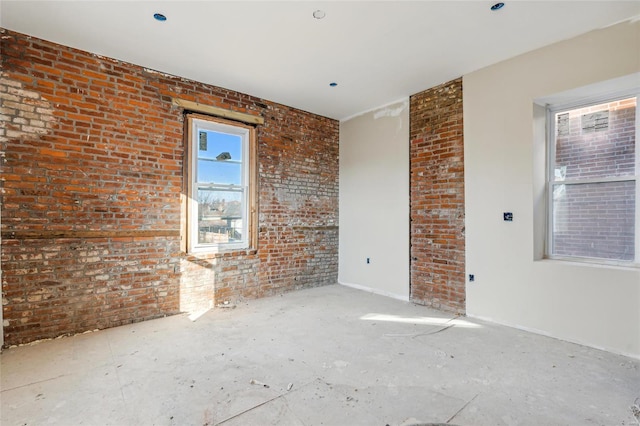 unfurnished room with brick wall