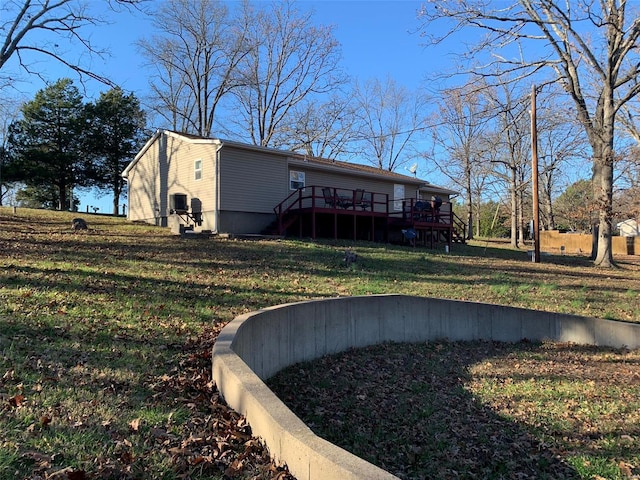 rear view of house featuring a yard and a wooden deck