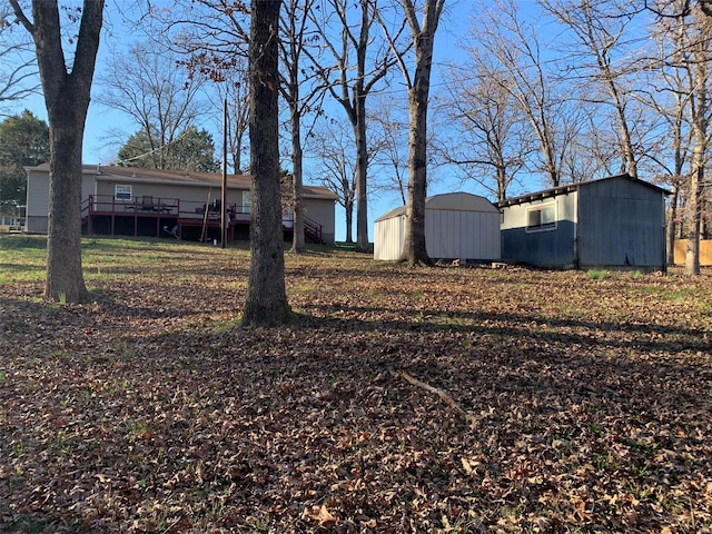 view of yard with a deck and a storage shed