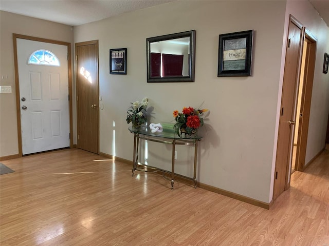 entryway with a textured ceiling and light hardwood / wood-style floors