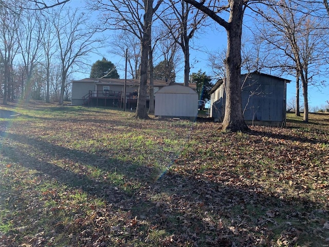 view of yard featuring a deck and a storage shed