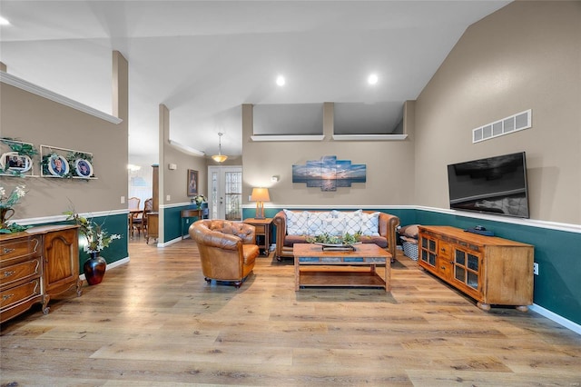 living room featuring light hardwood / wood-style flooring and high vaulted ceiling