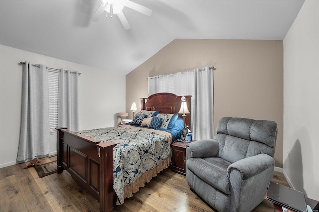 bedroom featuring multiple windows, ceiling fan, lofted ceiling, and light wood-type flooring